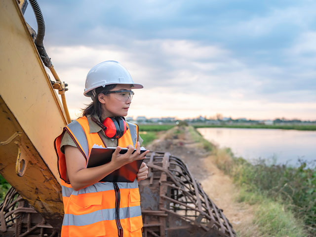 Construction worker making environmental notes on construction site