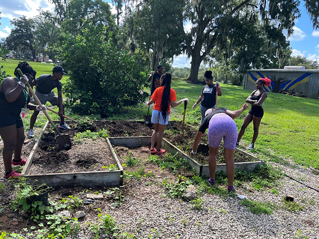 Students outside planting a garden